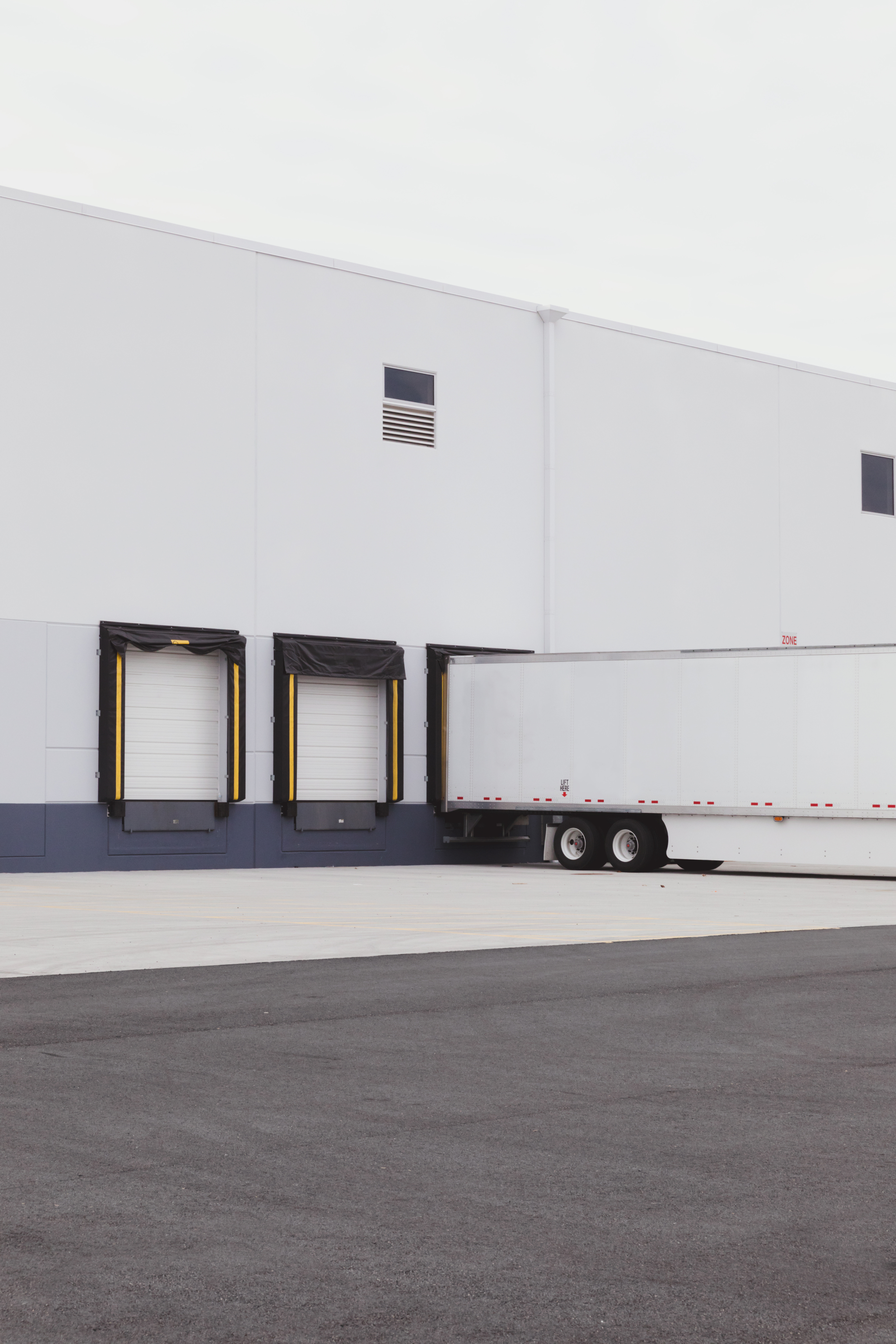 White freight trailer at a clean modern warehouse loading bay